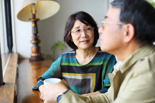 Woman in her 50s sitting with her husband having a cup of coffee